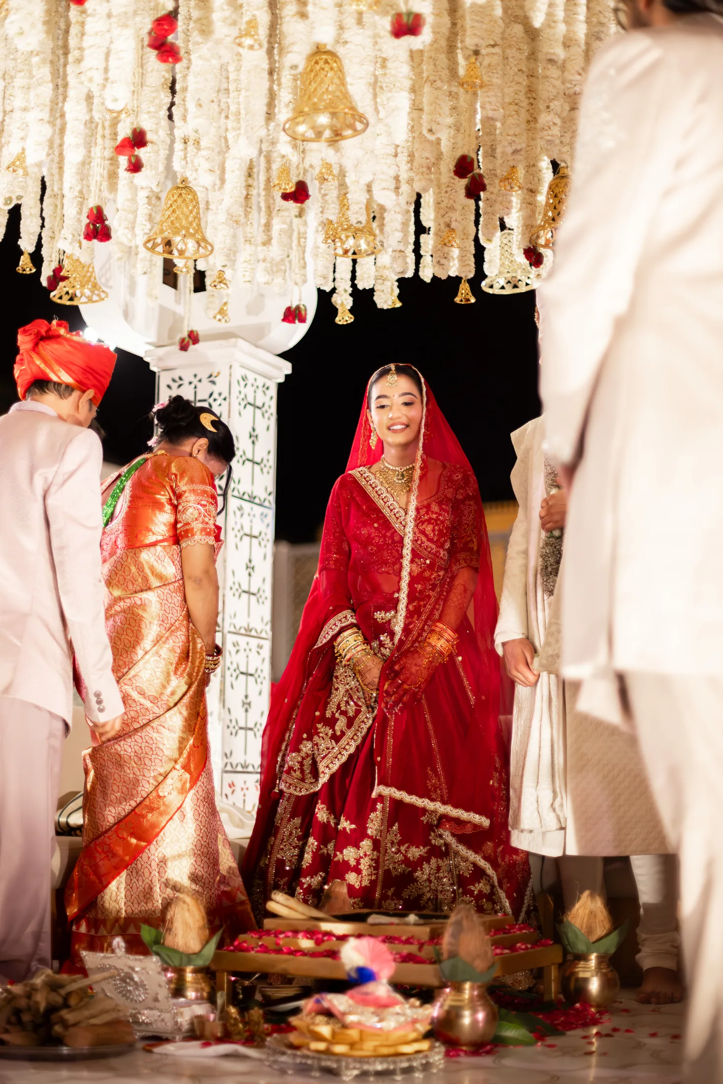 Serene stands beneath floral mandap details during the ceremony