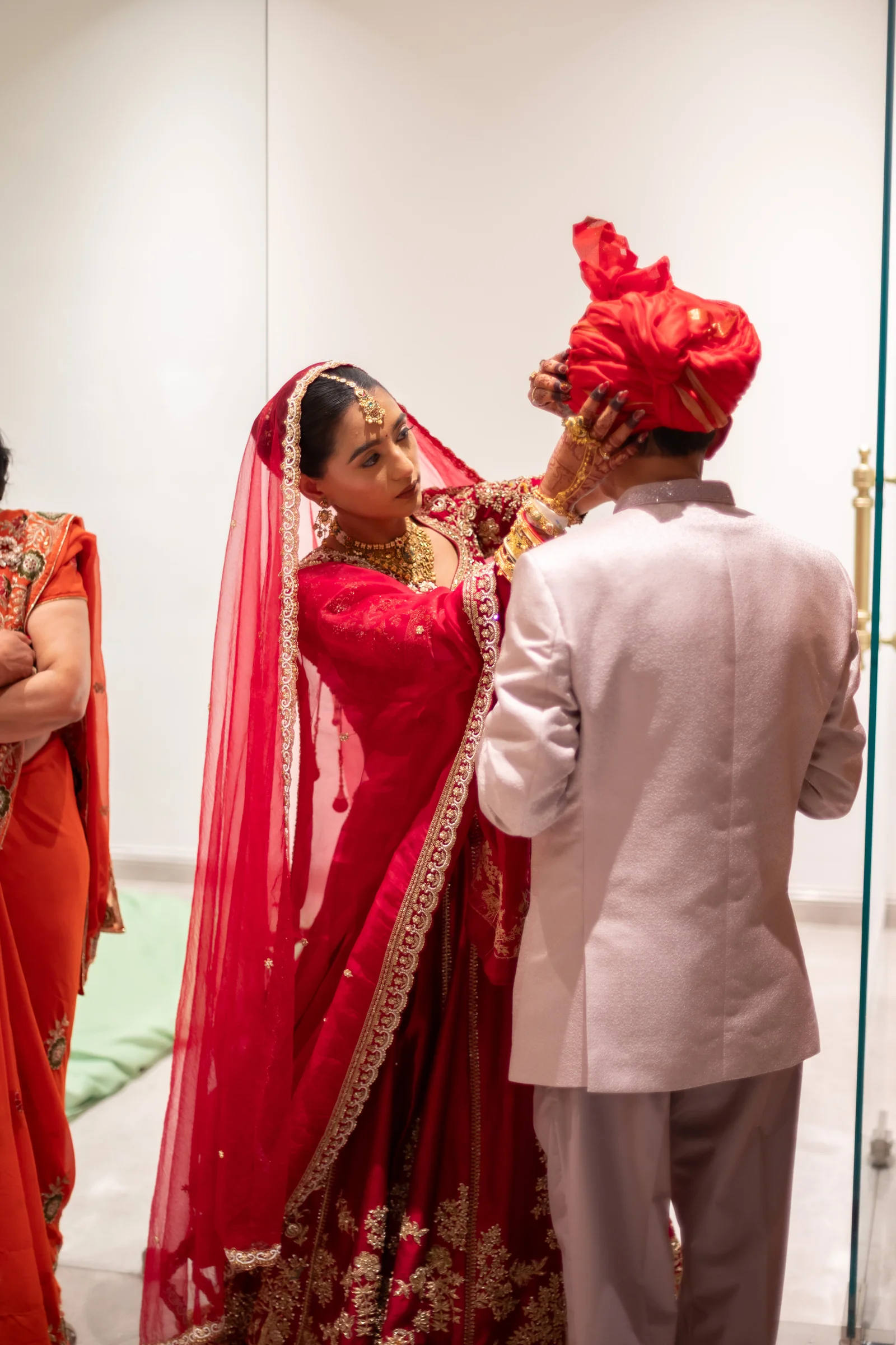 Serene carefully adjusts Jay's traditional wedding turban