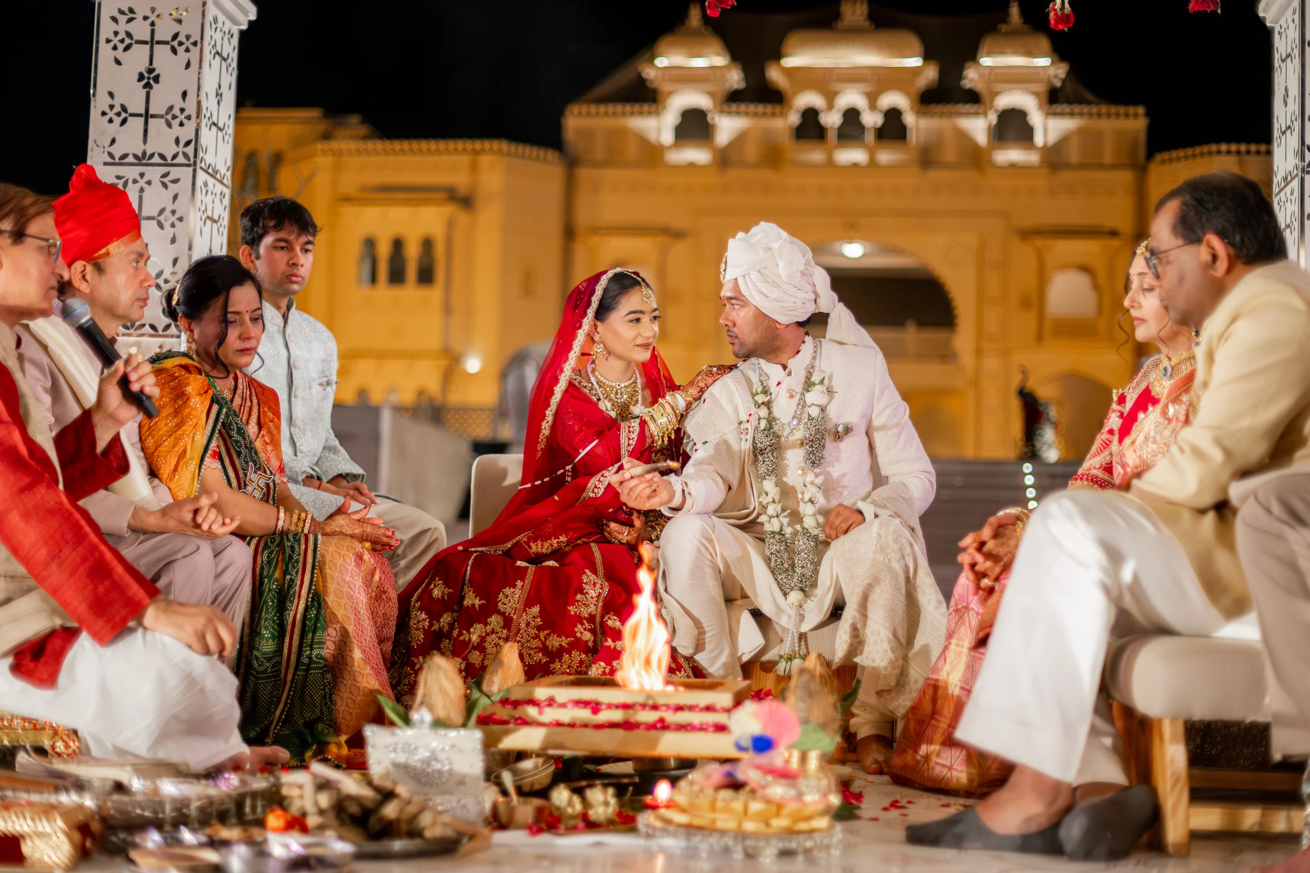 Jay and Serene seated together during their nighttime wedding ceremony