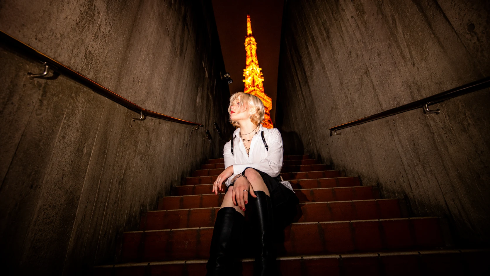 Ylva seated beneath the illuminated Tokyo Tower at night